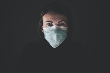 Scared young woman with medical face mask on